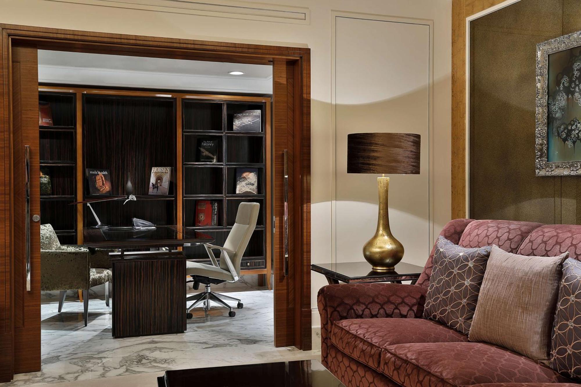 Hilton Riyadh Hotel & Residences Eksteriør billede The photo shows a stylish and modern interior space that appears to be a home office or study. In the foreground, there is a comfortable burgundy sofa with decorative pillows. Behind the sofa, there is a doorway leading to the office area, which incl