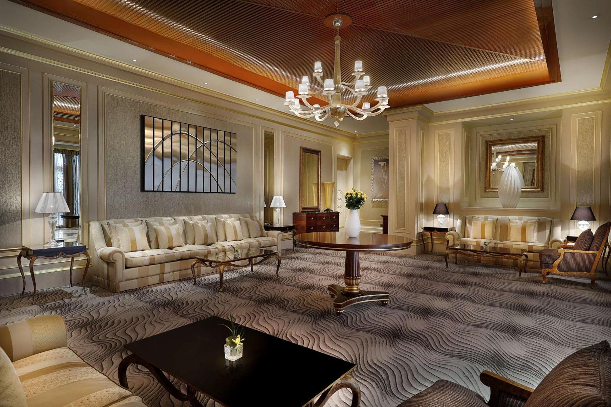 Hilton Riyadh Hotel & Residences Eksteriør billede The photo depicts an elegant and well-appointed living room or lounge area. It features a soft color palette with beige and cream tones throughout. 

1. **Furniture**: There are two plush sofas, a round wooden coffee table in the center, and a couple