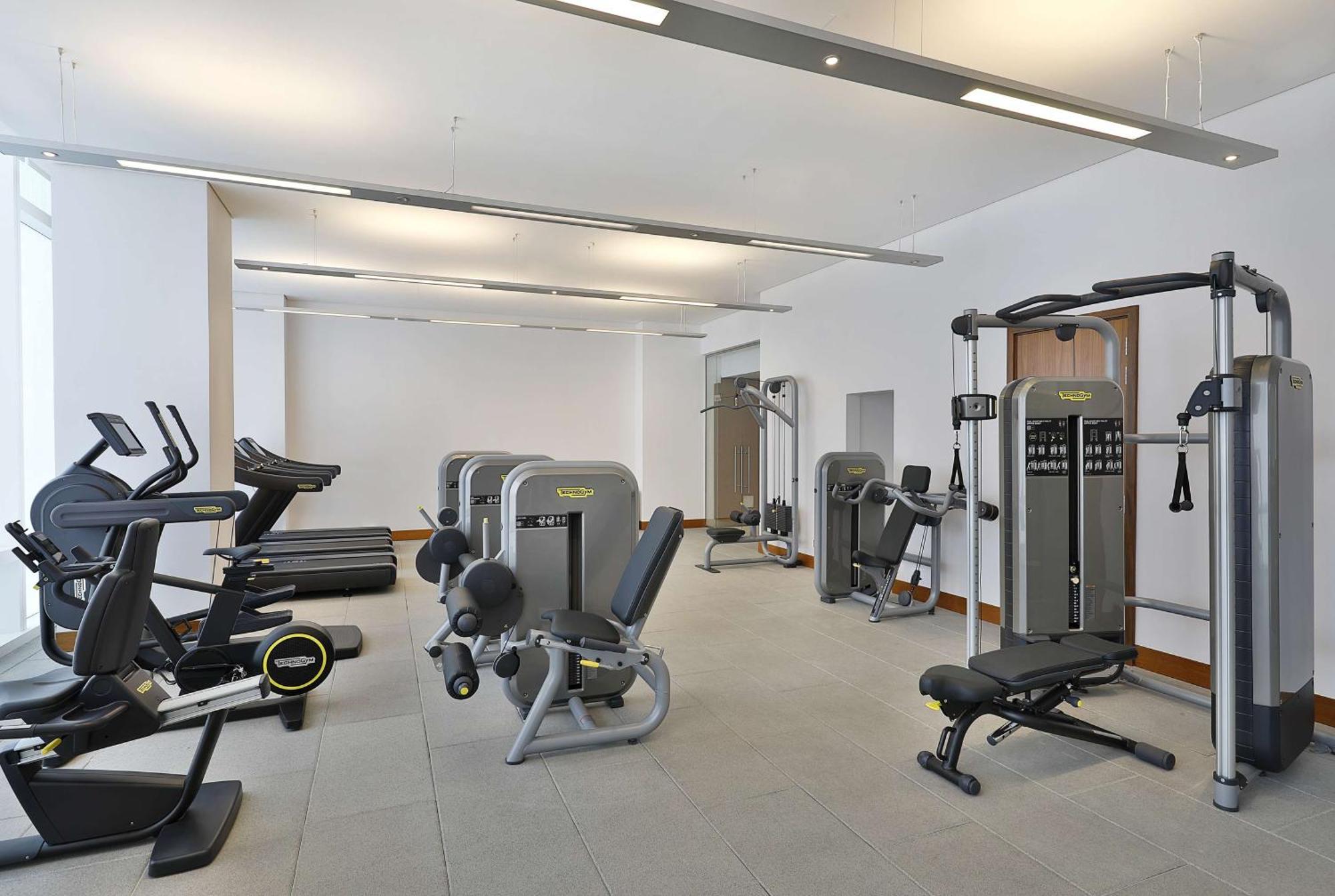 Hilton Riyadh Hotel & Residences Eksteriør billede The photo shows a modern gym or fitness center with various exercise equipment. On the left, there are several treadmills, while the center features a range of weight machines. There is a multi-station gym equipment, and a bench press is also visible